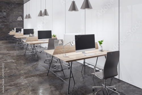 Perspective view on minimalistic style workspaces with modern computers on light wooden tables  black office chairs on dark marble floor near light matte walls. 3D rendering