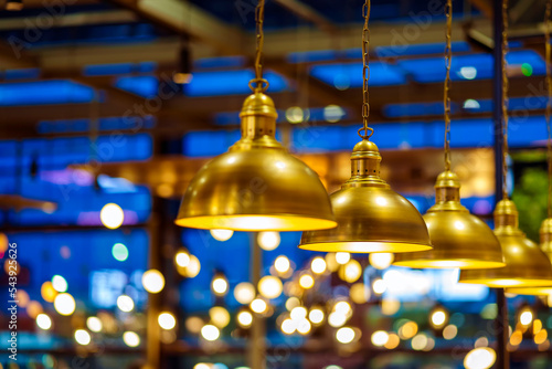 A row of vintage copper chandeliers on a blurry blue background