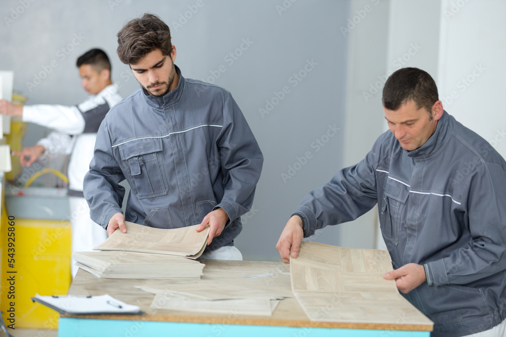 men installing new wooden laminate flooring men installing new wooden laminate flooring