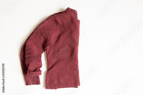 Red wool sweater lies on a white background, women's clothes © Виктория Котлярчук