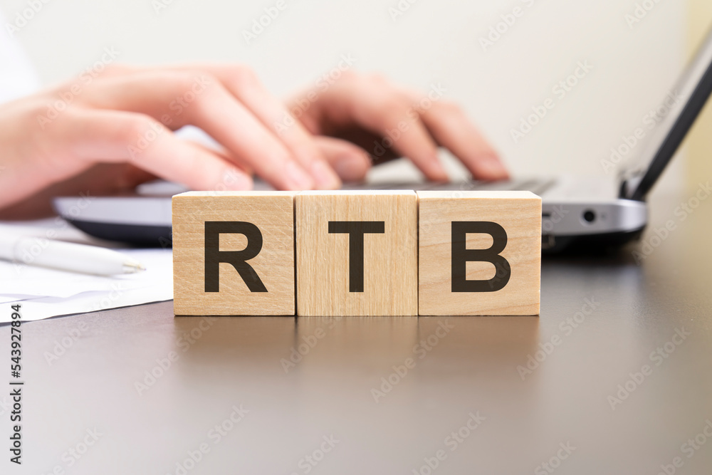 rtb - acronym from wooden blocks with letters. background hands on a ...