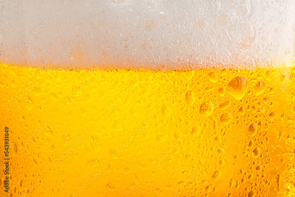 Glass of tasty cold beer with foam and condensation drops as background, closeup Glass of tasty cold beer with foam and condensation drops as background, closeup