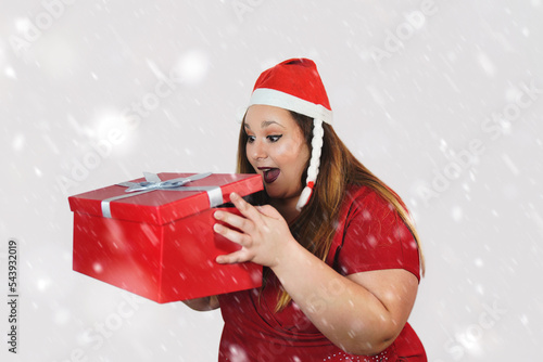 surprised plus size woman opening a gift box at christmas