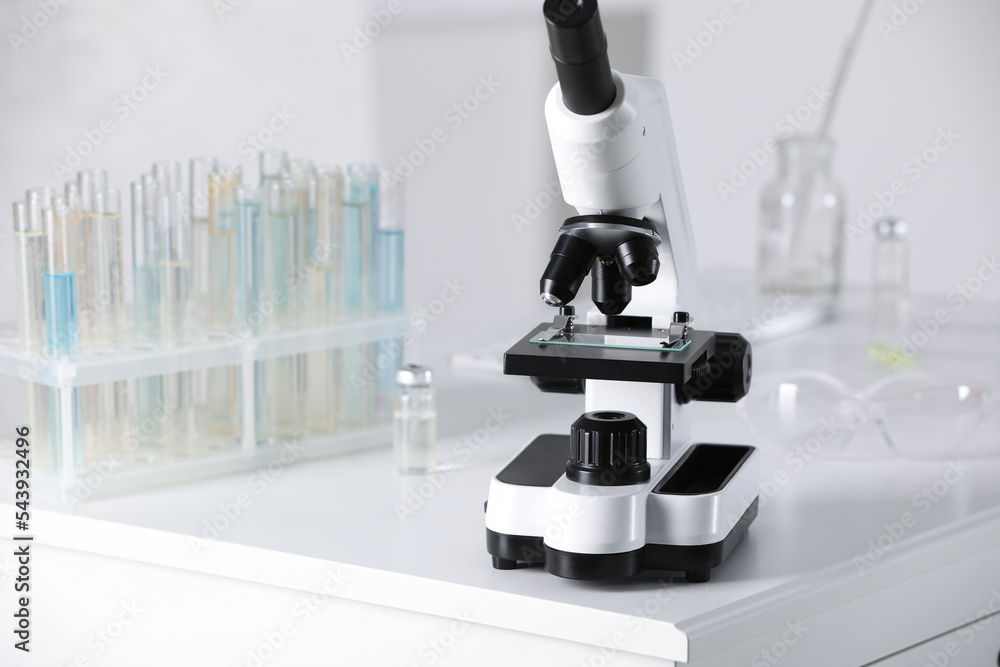 Modern medical microscope on white table in laboratory, space for text Modern medical microscope on white table in laboratory, space for text