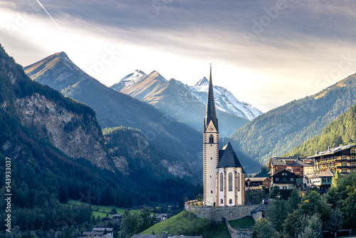 Kirche in Alpenlandschaft in warmer Abendsonne vor Bergmassiv