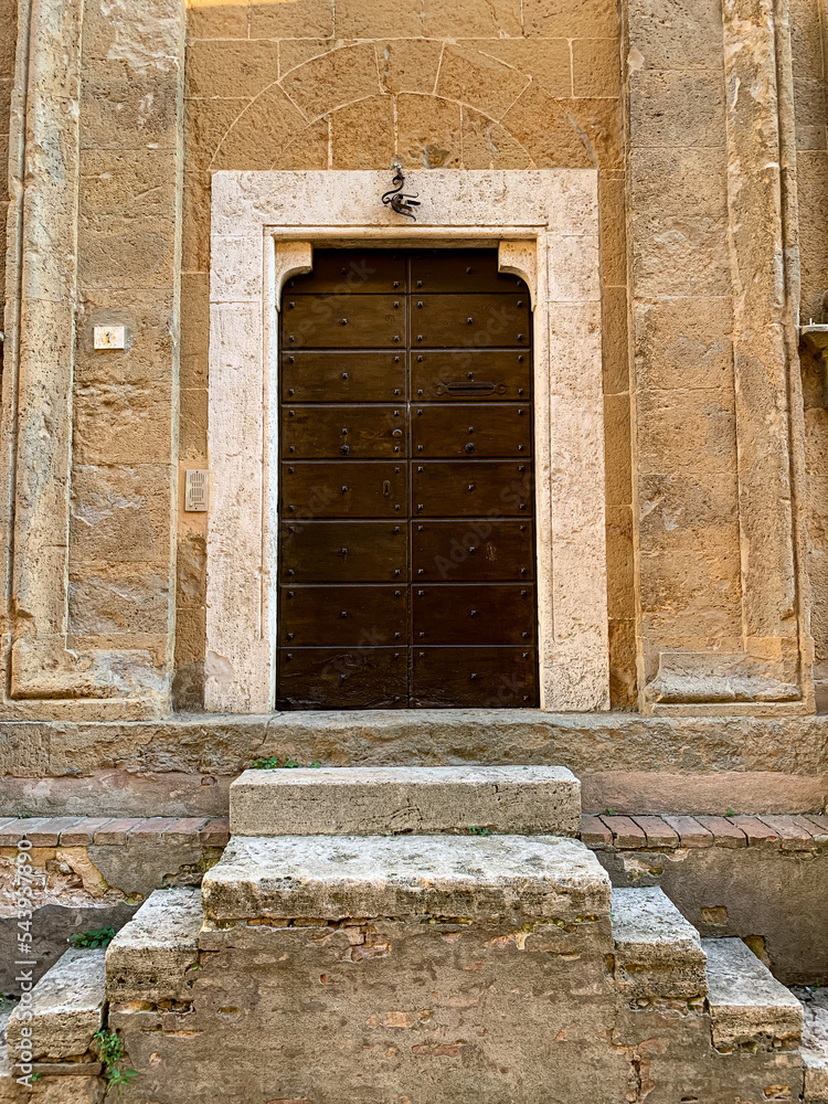 Side door of Duomo di Santa Maria Assunta, Pienza Cathedral. Pienza, Tuscany, Italy. Church from 1459 with Gothic & Renaissance elements, Sienese altarpieces and Romanesque sculptures. The Pienza Duom