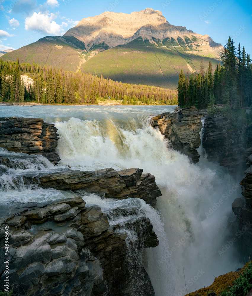 Powerful waterfalls of Athabasca Falls at sunset in summer. Jasper National Park, Alberta, Canada.