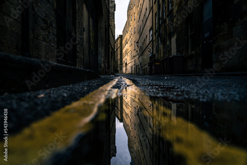 A street after rain, reflections of the houses in the puddle, dark mood