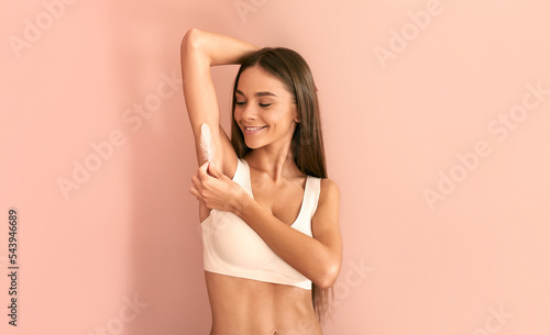 Tableau sur toile Beautiful young woman with long hair in white underwear touches armpit feathers and smiles