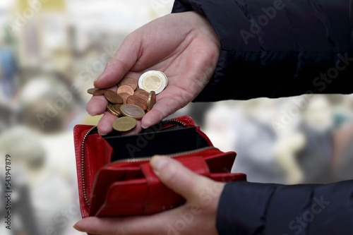 Fotografie poor woman counting coins near the cash register in the store