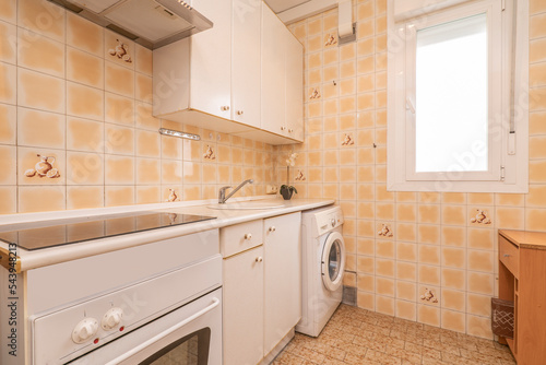 Kitchen with white wooden furniture with matching countertop and small yellow tiles