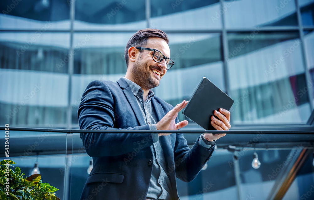 Happy smiling businessman making video call with his client via tablet. Business, lifestyle concept Happy smiling businessman making video call with his client via tablet. Business, lifestyle concept