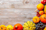 Autumn thanksgiving background with pumpkins, grapes and red rowan on wooden table. Top view with copy space for your text