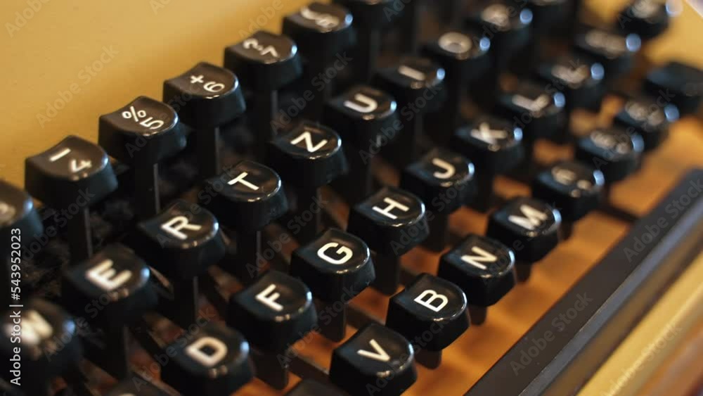Evolution of communication and technology concept. Closeup shot of authentic well-preserved yellow typewriter with black push-button. Focus on the foreground. Blurred background. High quality 4k Evolution of communication and technology concept. Closeup shot of authentic well-preserved yellow typewriter with black push-button. Focus on the foreground. Blurred background. High quality 4k