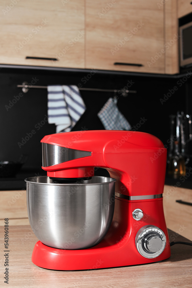 Modern stand mixer on wooden table in kitchen