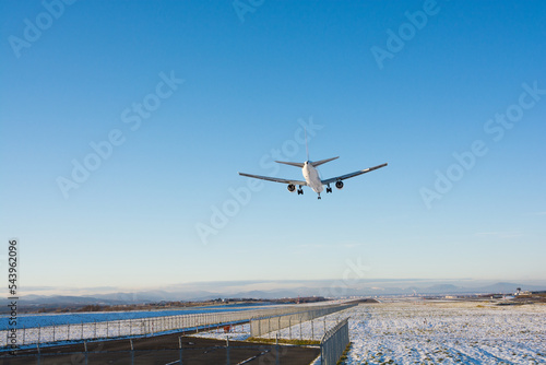 冬の空港に着陸するジェット旅客機