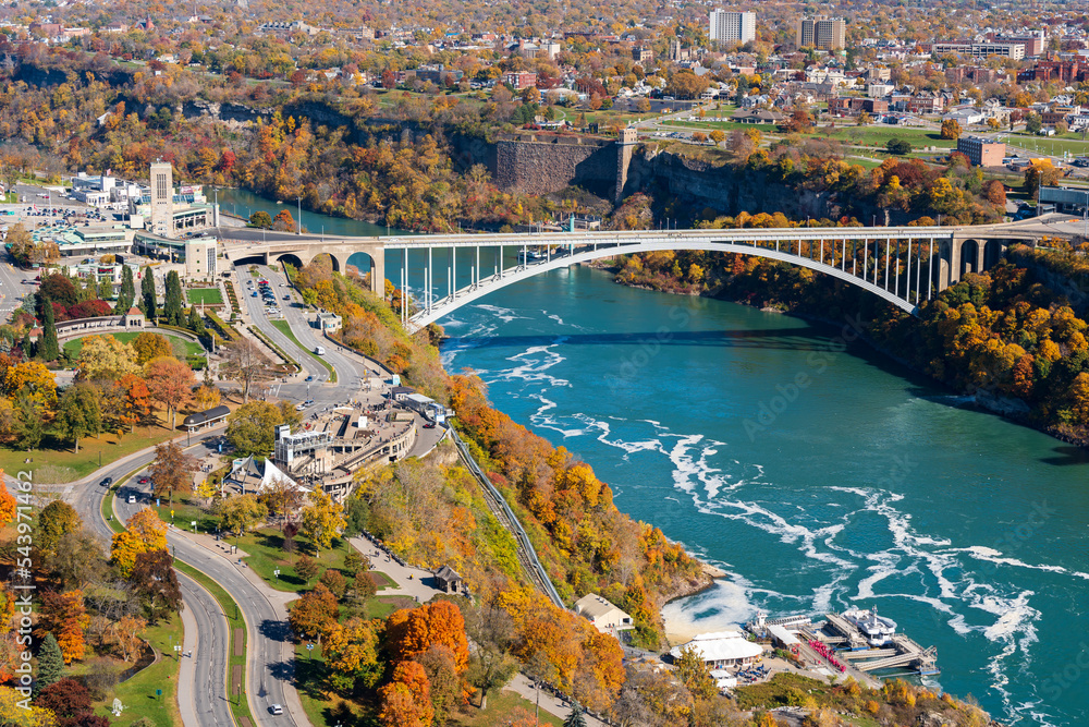 Niagara Falls City, Ontario, Canada - October 27 2022 : Niagara River Rainbow Bridge in a sunny day in autumn foliage season.