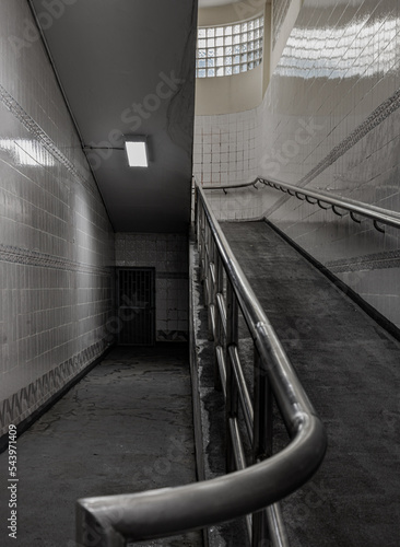 Bangkok, Thailand - Sep 30, 2022 : Stairs leading to interior view of public underpass with white tiled walls and CCTV. Space for text, No focus, specifically.