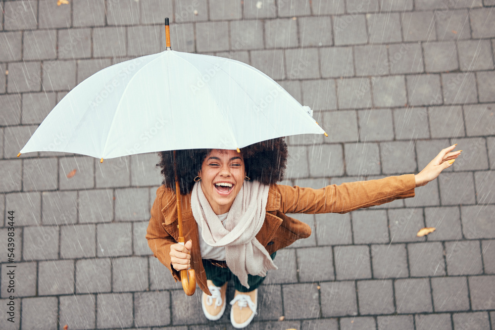 Black woman, umbrella and rain with smile, happy and enjoy weather in city being wet. Winter, young female and happiness for storm, cheerful and joyful with cover, comfortable and rainy outdoor. - obrazy, fototapety, plakaty 