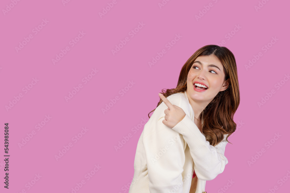 Portrait of happy cheerful young woman pointing to empty copy space for product over isolated pink background Portrait of happy cheerful young woman pointing to empty copy space for product over isolated pink background