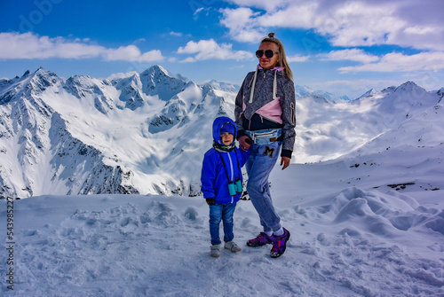 A girl with a silver on the background of mountains in winter and a snow-covered peak. The Caucasus Mountains. Elbrus 2019
