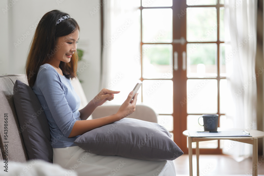 Work from home concept, Business women check monthly income on phone while working remotely at home Work from home concept, Business women check monthly income on phone while working remotely at home