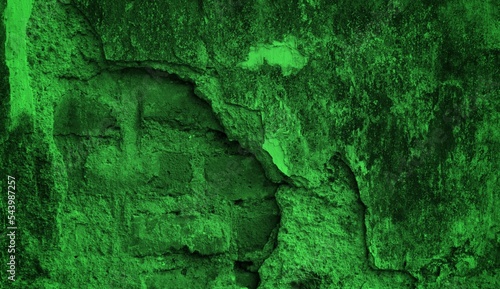 background concept using green cracked old wall material, chipped wall surface forming abstract art, old green themed wall background