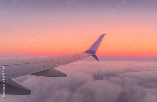 Canvas Print Wing with an engine of a commercial airline flying above the clouds against the