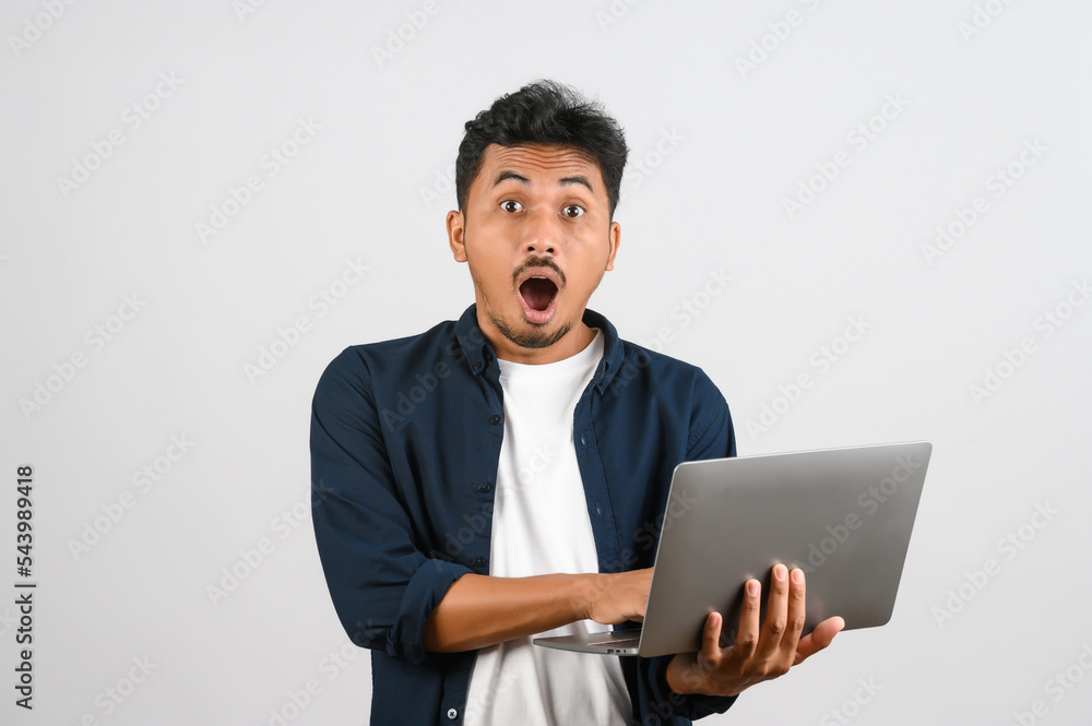 Portrait of shocked asian businessman working on laptop computer isolated over white background Portrait of shocked asian businessman working on laptop computer isolated over white background