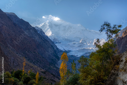 beautiful autumn  landscape of colorful trees mountains and dramatic sky 