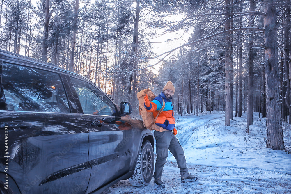 Hiking sport forest extreme winter, male traveler with a backpack next to a car in the forest view