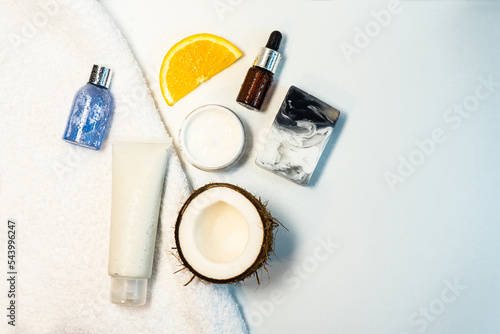Care cosmetics and coconut on a white table. A product for hair, body, skin. flatley. Natural Spa ingredients. Split coconut. The concept of spa, skin care, hair and relaxation. Selective focus. 