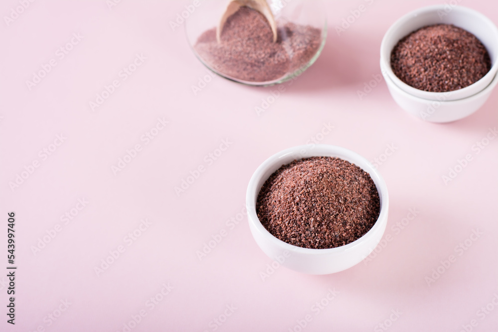 Black Himalayan rock salt kala namak in bowl on pink background Black Himalayan rock salt kala namak in bowl on pink background