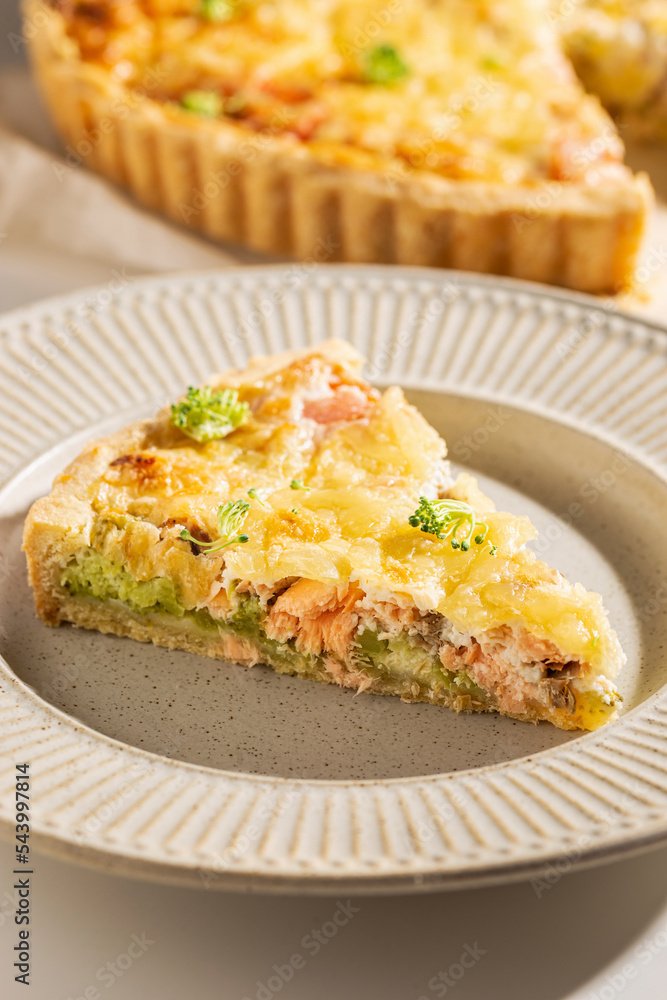 Piece of freshly baked quiche with salmon and broccoli
