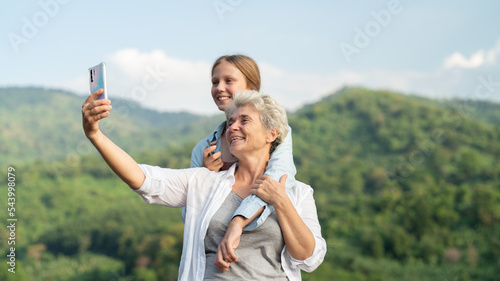 A woman happily uses a mobile phone to take pictures of the landscape on the hillside.happy women enjoying nature travelhappy women enjoying nature travel. photo