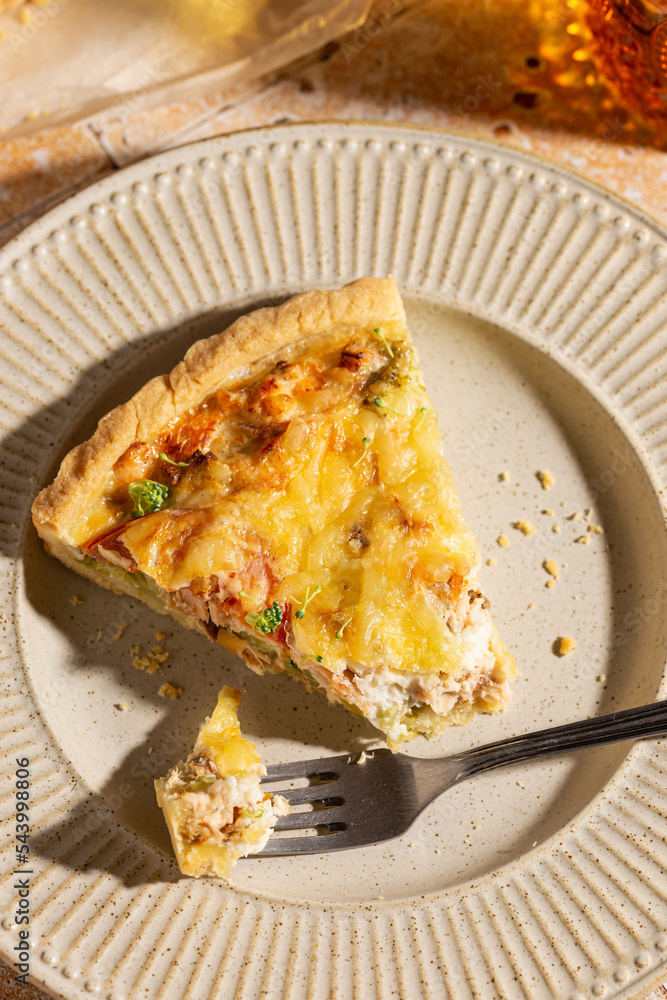 Piece of freshly baked quiche with salmon and broccoli Piece of freshly baked quiche with salmon and broccoli