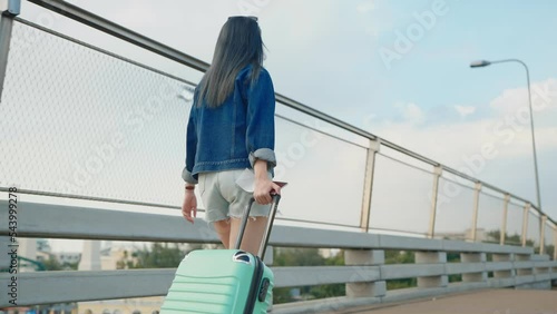 Wallpaper Mural Asian woman traveler walking dragging a suitcase holding a passport and boarding pass. Background sky and airplane Torontodigital.ca