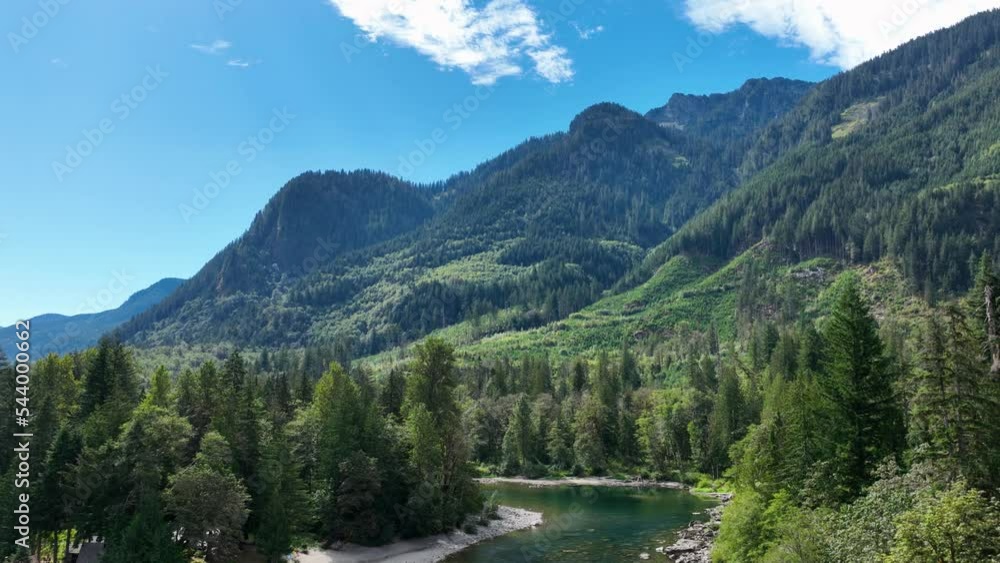 Aerial view revealing the Skykomish River passing through the Cascade Mountains on a sunny day. Aerial view revealing the Skykomish River passing through the Cascade Mountains on a sunny day.