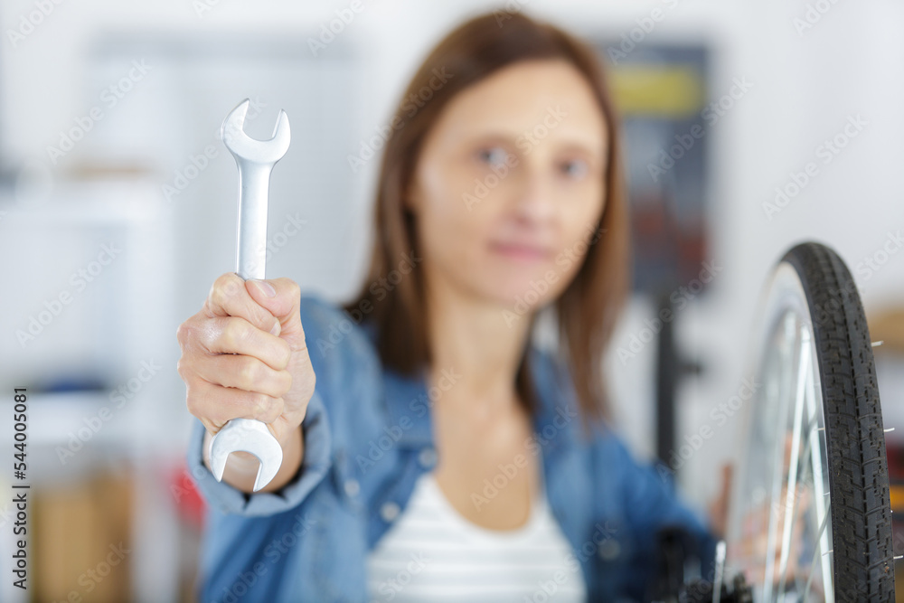 female bicycle mechanic showing a spanner Stock Photo Adobe Stock