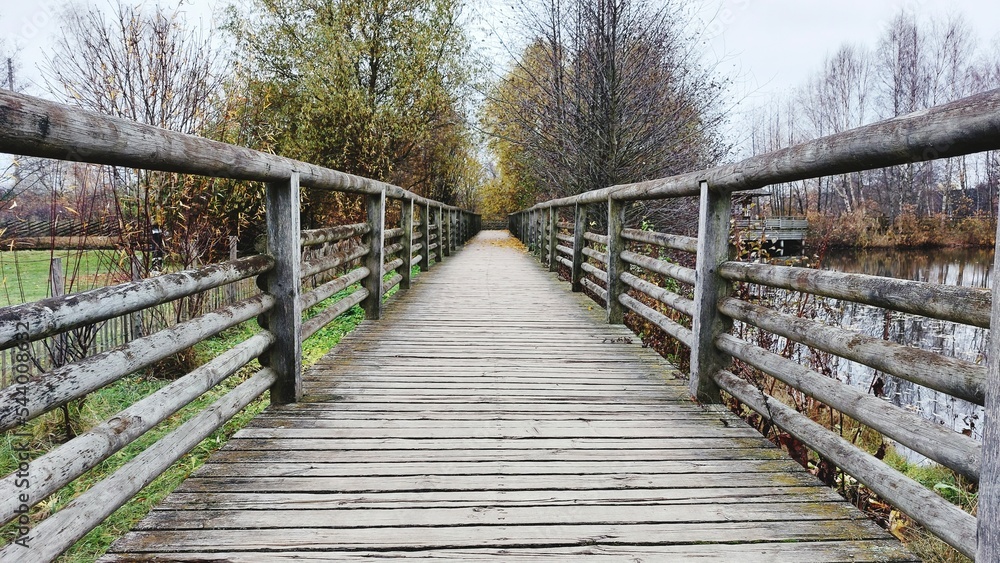 Long wooden bridge autumn fall park river