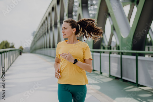Konstfotografi Young woman jogging at city bridge, healthy lifestyle and sport concept