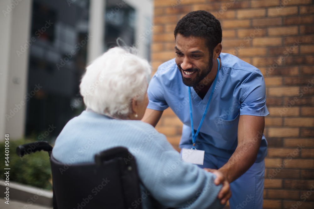 © Halfpoint - Senior woman at wheelchair spending time outside with her assistant.
