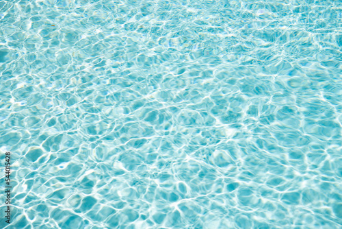 summer paradise. blue swimming pool water background with ripples