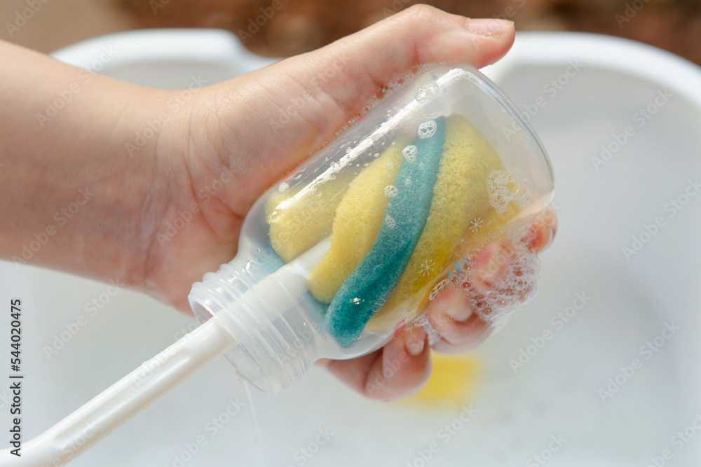 Washing baby bottle. Mother's hand washing the baby bottle.. Washing baby bottle. Mother's hand washing the baby bottle..