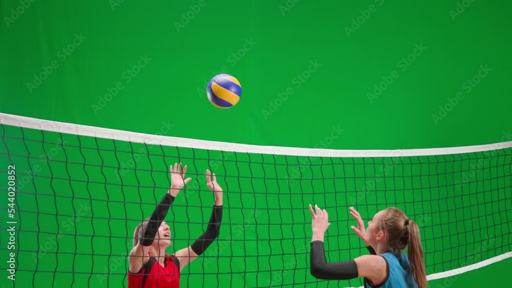 Video „Two young women in blue and red uniforms playing volleyball on
