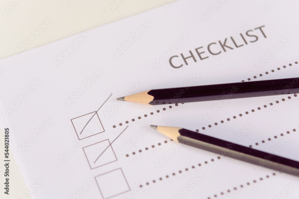 Checklist concept - checklist form paper and pencil on white table Checklist concept - checklist form paper and pencil on white table