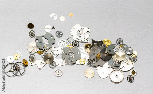 Fototapeta Naklejka Na Ścianę i Meble -  metal parts of the clock mechanism, in assortment for all types of repairs on a white milky background.