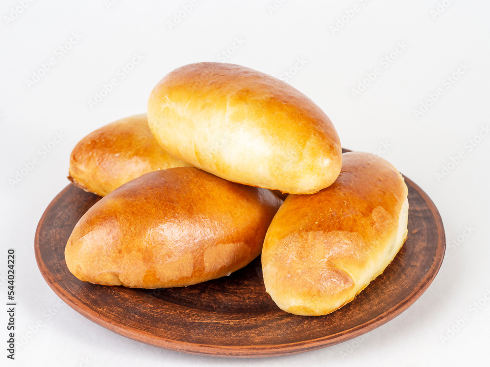 Pies on a dark plate on a white background. Pies on a dark plate on a white background.