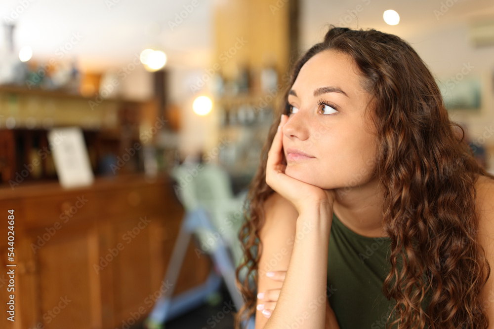Distracted and pensive woman in a restaurant