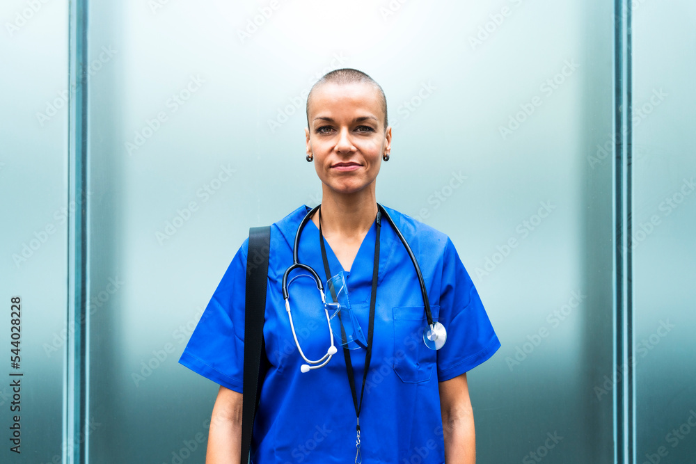 Mature female nurse with stethoscope in front of wall Mature female nurse with stethoscope in front of wall